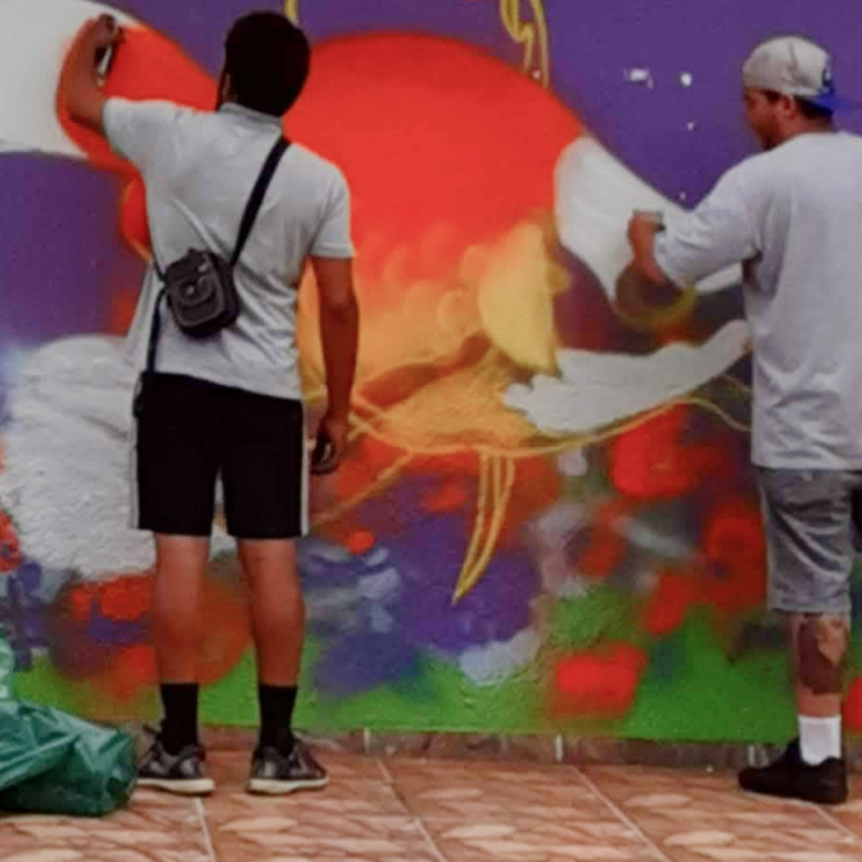 Héu e Gago realizando pintura em escola pública após realização de oficna com crianças de 6 a 10 anos. 2020